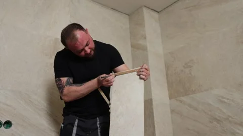 Tiler installing large format tile on bathroom wall Stock Footage 345681374