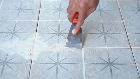 Tiler laying the ceramic tile on the floor. Grouting ceramic tiles. Stock Footage 233832439