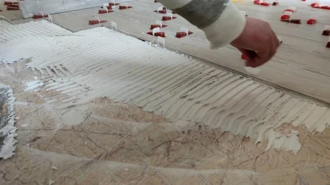Tiler lays down a system of alignment of a tile Stock Footage 154372054