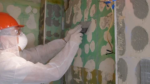 Tiler making renovation, removing cement from wall in toilet using tool spatula. Stock-Footage 124862480
