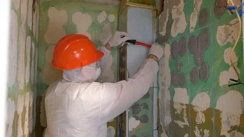 Tiler making renovation, removing tiles from wall in toilet using crowbar. Video stock 124861925