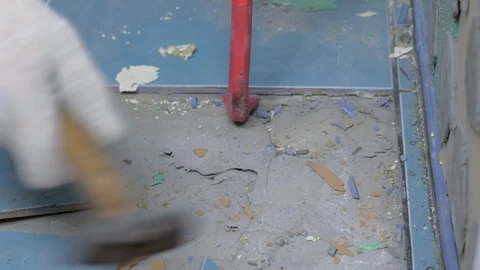 Tiler making renovation, removing tiles from floor in toilet using crowbar. Video stock 124897011