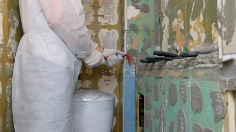Tiler making renovation, removing tiles from wall in toilet using crowbar. Stock Footage 125041482