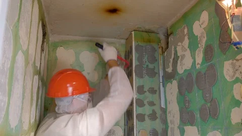 Tiler making renovation, removing tiles from wall in toilet using crowbar. Stock Footage 129432814