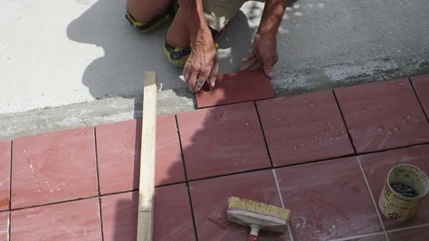 Tiler restoring sidewalk laying of tile in construction Video stock 101402624