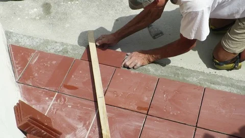 Tiler restoring sidewalk laying of tile in construction Vídeo Stock 101402629