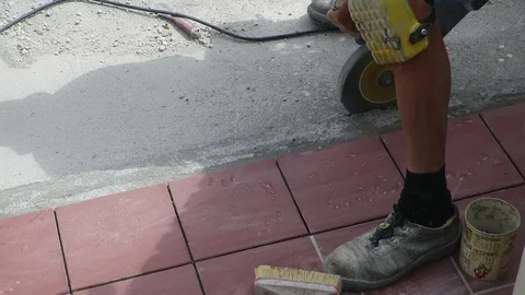 Tiler restoring sidewalk laying of tile in construction Stock Footage 101402639