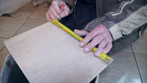 Tiler with tape measure space for tile closeup Stock Footage 103472893