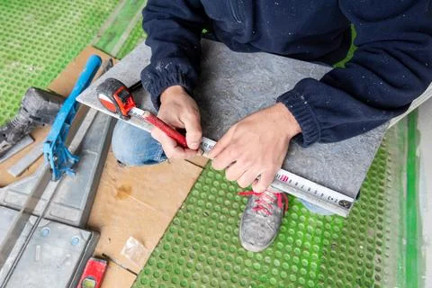 Tiler at work installing new floor with tiles. Construction. Fotos de archivo