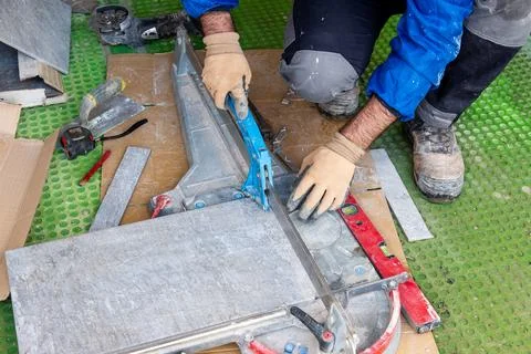 Tiler at work installing new floor with tiles. Construction. Stock Photos