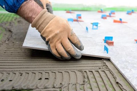 Tiler at work installing new floor with tiles. Construction. Foto stock