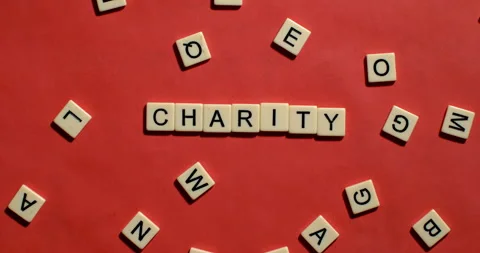 Tiles fall slow motion and spell Charity in Scrabble Video stock 254037831