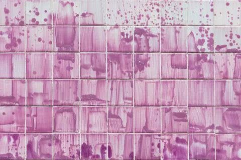 Tiles on the wall of a building with expressive patterns painted with pink paint Foto stock