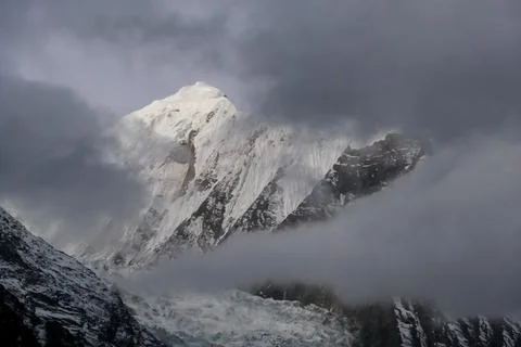 Tilicho Base Camp - High snow capped peaks of Himmalyas hiding behind the clouds Stock Photos