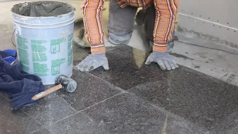 Tiling work, builder laying tiles, stone tiles, tile mortar, finishing work Stock Footage 303406667