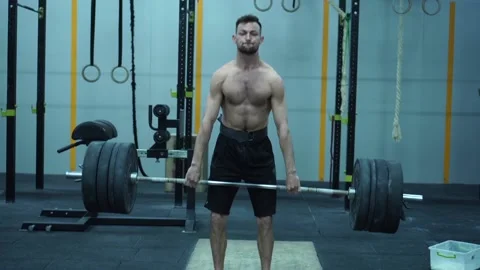 Tilt up and down of strong young aged man lifting barbell with heavy plates. Stock Footage 132724463