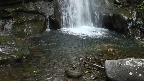 Tilt up and down a waterfall in the mountains Video stock 99314356