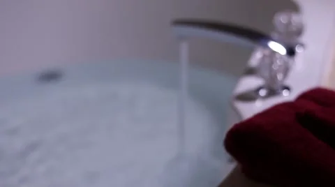 Tilt up and rack focus from wine glasses to jacuzzi tub faucet Stock Footage 58669399