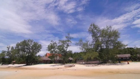 Tilt of blue sky and bugalows on a beautiful beach Stock Footage 76730110
