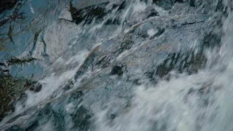 Tilt up Camera Close up Strong Flowing and Splash Water Through Dark Rough Rock Stock Footage 154017078