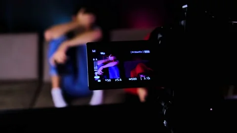 A tilt up camera shot of a camera recording an two young guys are sitting on the Stock-Footage 134205205