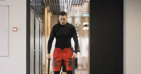 Tilt up to a closeup of a man's face working out with Battle Ropes Stock Footage 75869227