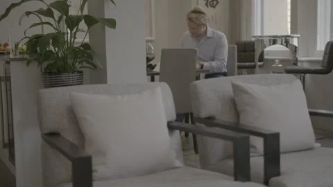 Tilt Up from Coffee Cup to Man Working on Laptop at Home Stock Footage 344604348