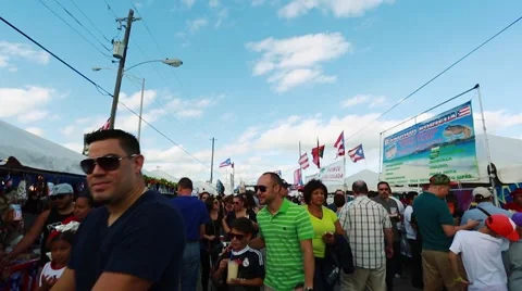 Tilt up of crowd of people walking around during festival. Puerto Rican flags Stock Footage 47822728