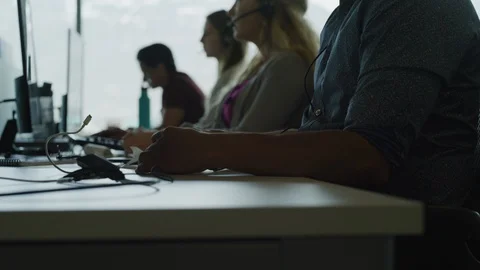 Tilt up to customer service representatives talking on telephones in call center Stock Footage 109571762