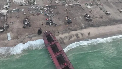 Tilt up descending shot of breaking yard with the ship hull on the Stock Footage 256149739