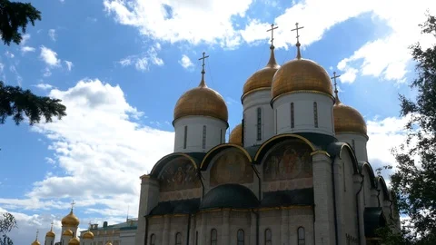 Tilt up on Dormition Cathedral inside Moscow Kremlin with a cloudy blue sky Stock Footage 99257545