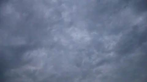 Tilt down accumulating clouds over waves touching sandy beach Stock Footage 84725906