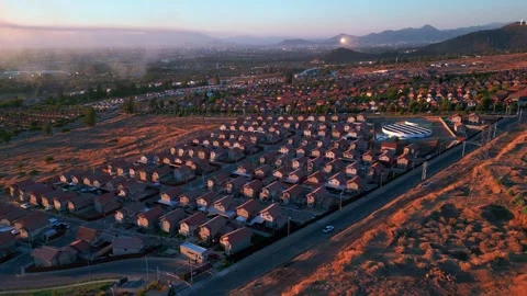 Tilt down aerial shot over dense uniform residential suburb surrounded by dry Stock Footage 336267316