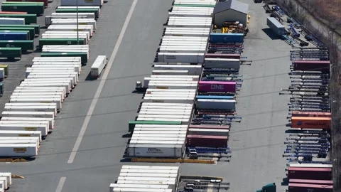 Tilt down aerial view of ONE shipping containers truck parking Vídeo Stock 344597110