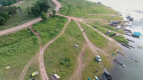 Tilt down aerial views above pathways leading to Lam Pao fishing waters. Stock Footage 108401460