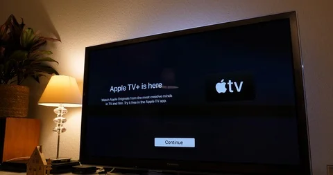 Tilt-down to Apple TV plus is here message on living room display Stock Footage 120365020