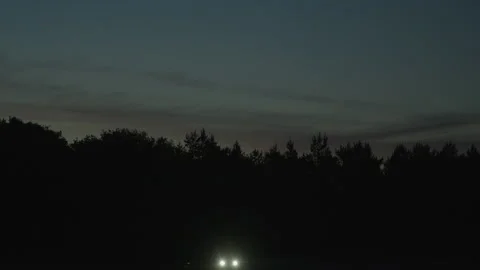 Tilt down from beautiful night sky to car parked with burning headlights 스톡 동영상 197291408