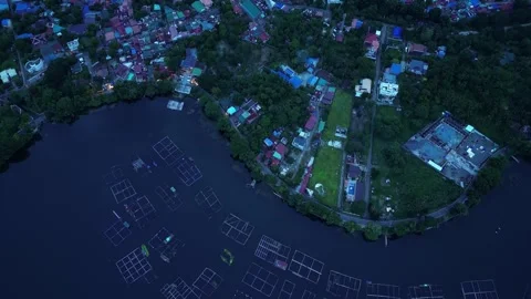 Tilt down blue hour featuring Sampaloc Lake, residential communities, parks Vidéo 343079692