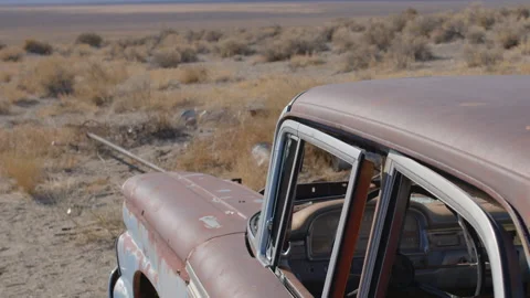 Tilt Down from Blue Sky and Clouds to Junked Car in Desert - Shallow DOF Video stock 144043894