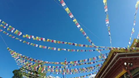 Tilt down from blue sky and colorful prayer flags to Soma Gompa building. Stock Footage 262297949