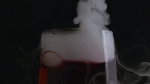 Tilt down on bubbling smoking red champagne flute in macro Stock-Footage 70706085