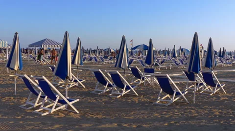 Tilt down on the closed umbrellas at the beach. Stock Footage 54662709