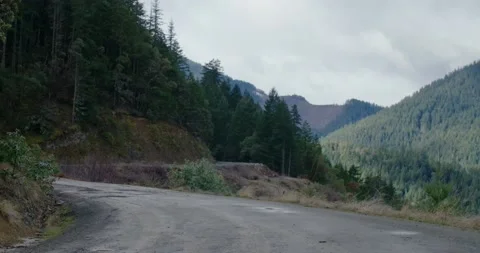 Tilt Down From Clouds to Forest Mountain Road Stock Footage 162789873