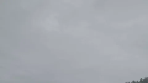 Tilt down from clouds to forested lake with sail boats Stock Footage 127121278