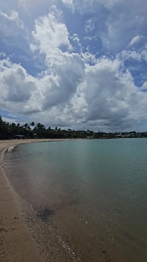 Tilt down from Clouds to Shallow Bay Water, Airlie Beach, Queensland, Australia Stock-Footage 299045476