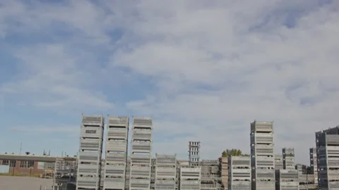 Tilt down from a cloudy sky to stacked materials on an industrial storage yard Stock Footage 318347476