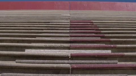 Tilt down of concrete steps in a high school football stadium Stock Footage 77081293