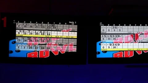 Tilt down from digital scoreboard to friends competing in bowling together, club Stock Footage 70669951