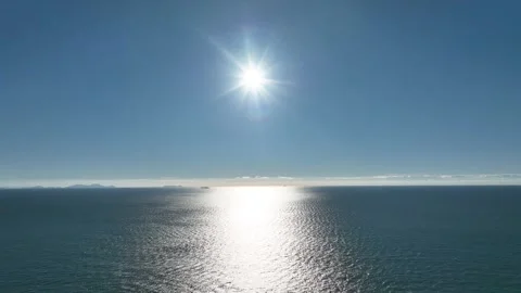 Tilt-down drone view of sunlight over the ocean with shimmering water Stock Footage 313171653