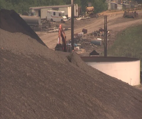 Tilt down to dump truck filled with coal on dusty road at Century Mine Stock Footage 86695973